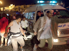  <p class='fr'>
Les morts et les blessés, transportés en ambulance, à moto ou en voiture, affluent dans cette mosquée convertie en dispensaire, sur la place du Changement.


	</p> <p class='en'>
	The injured, brought in by ambulance, car or motorcycle, and the dead are taken to the mosque on Change Square which is now operating as a first aid center.

	</p>