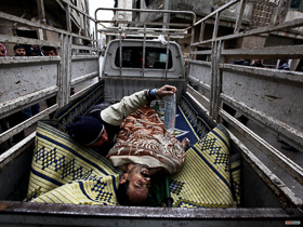 Syrie, Homs. Quartier de Karm al-Zaytoun. <p class='fr'>
	Un homme blessé par un sniper est évacué dans une camionnette qui est elle-même susceptible d’être la cible de tirs. L’homme blessé ne survivra pas.

	</p> <p class='en'>
	A man hit by sniper fire is evacuated in a vehicle which is then likely to be targeted. The man did not survive.
	</p>