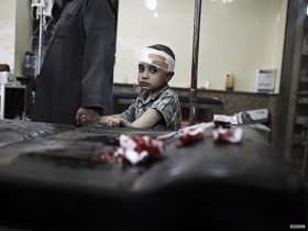  <p class='fr'>
	Un enfant blessé avec son père. Il vient d’être soigné par la toute petite équipe médicale qui travaille dans cette antenne de soins.
	</p> <p class='en'>
	An injured child with his father after being treated by the very small team at a medical facility.

	</p>