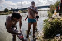 
<p class='fr'>
Waleed (à gauche), un migrant koweïtien, et Yaser, un migrant irakien, se lavent dans une rivière qui borde un camp de fortune près de Dunkerque. 2 septembre 2020.</p>
<p class='en'>
Waleed (left), from Kuwait, and Yaser, from Iraq, in a river running by a makeshift camp near Dunkirk. September 2, 2020.</p>