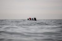 
<p class='fr'>
Des migrants à bord d’un bateau naviguant dans des eaux agitées entre Sangatte et le cap Blanc-Nez, dans la Manche, alors qu'ils tentent de franchir la frontière maritime entre la France et le Royaume-Uni. 27 août 2020.</p>
<p class='en'>
Migrants attempting to cross the English Channel on board a dinghy tossed on the waves between Sangatte and Cap Blanc-Nez off the French coast. August 27,  2020.</p>