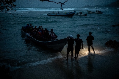 
<p class='fr'>

Un groupe d’Afghans à bord d’une embarcation en Colombie, en direction du Darién. Le capitaine aboie ses ordres et leur dit d’éteindre leurs portables pour ne pas être repérés par la police. Puis le moteur a rugi et les 54 Afghans sont partis en trombe le long de la côte, pleurant, vomissant et priant. Ils étaient nombreux à voir la mer pour la première fois.

</p>

<p class='en'>

A group of Afghans aboard a boat in Colombia, heading for the Darién Gap. The captain barked orders, telling them to turn off their mobile phones so they would not be detected by the police. The motor roared, and the 54 Afghans sped up the coast, crying, vomiting and praying. For many it was the first time they had seen the open sea.
</p>

