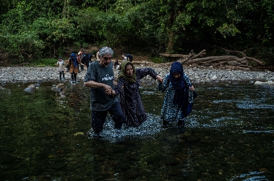 
<p class='fr'>

Des Afghans épuisés s’aident à traverser une rivière alors qu’ils approchent de la fin de la traversée du Darién.

</p>

<p class='en'>

A group of exhausted Afghans help one another across a river as they reach the end of the Darién Gap.
</p>
